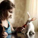 Зайцы Девочка кормит кролика морковью аватар